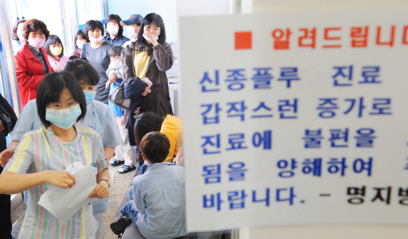 26일 경기 고양시 명지병원 신종플루대응진료센터를 찾은 유사 증상자와 가족들이 마스크를 착용한 채 걱정스러운 표정으로 진료 순서를 기다리고 있다. 정연호기자 tpgod@seoul.co.kr