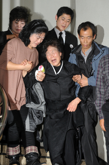 28일 서울 서초동 중앙지법에서 열린 용산참사 1심 선고공판에서 농성자들에게 징역 5~6년의 중형이 선고되자 참사 당시 사망한 고 이상림씨의 아내 전재숙(가운데)씨가 오열하며 가족들의 부축을 받고 법정을 나오고 있다.  도준석기자 pado@seoul.co.kr