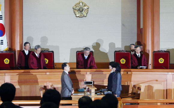 29일 서울 가회동 헌법재판소에서 열린 미디어법 권한쟁의 심판에 앞서 이강국(윗줄 가운데) 소장과 재판관들이 대심판정으로 들어와 자리에 앉고 있다. 헌재는 이날 ‘절차는 위법하나 결과는 위법하지 않다.’는 결론을 내렸다. 도준석기자 pado@seoul.co.kr