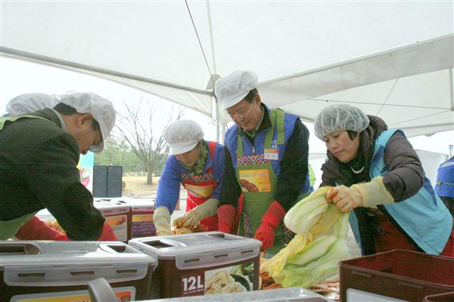 지난 14일 충남 서산 대산공장에서 열린 ‘행복한 김장 나눔행사’에서 유석렬(오른쪽 두번째) 삼성토탈 사장이 직원 가족들과 함께 김장을 하고 있다.  삼성토탈 제공
