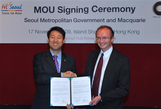 오세훈(왼쪽) 서울시장이 매쿼리사의 게리 패럴 최고경영자와 양해각서를 교환한 뒤 악수하고 있다. 서울시 제공