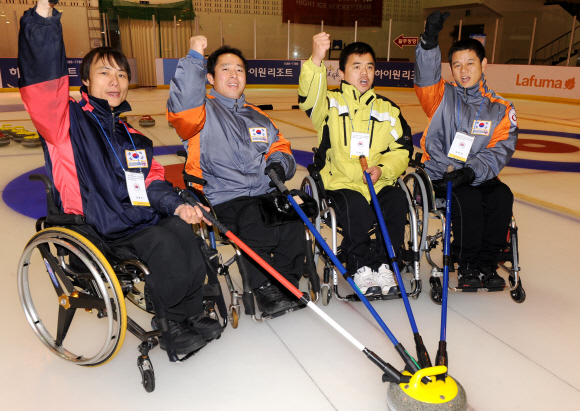 국가대표 휠체어컬링팀 대표들이 지난 30일 강원 춘천시 의암빙상장에서 큐를 들고 파이팅을 외치고 있다. 왼쪽부터 김명진, 조양현, 박길우, 김학성 선수. 춘천 류재림기자 jawoolim@seoul.co.kr