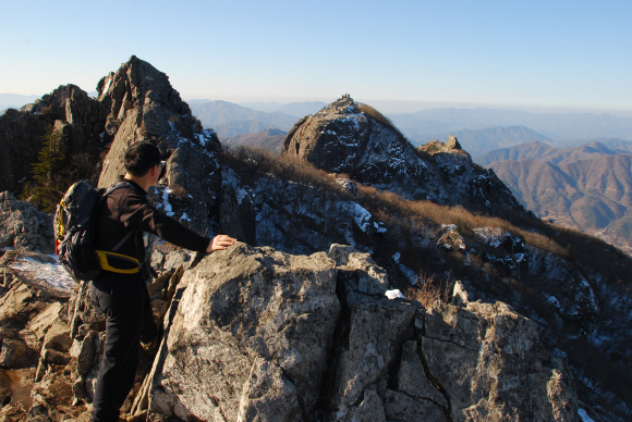 칠불봉에서 상왕봉(가운데)을 바라보는 산꾼. 가야산 정상 일대는 멀리서 보면 소머리를 닮았다고 해서 우두봉으로도 불린다.