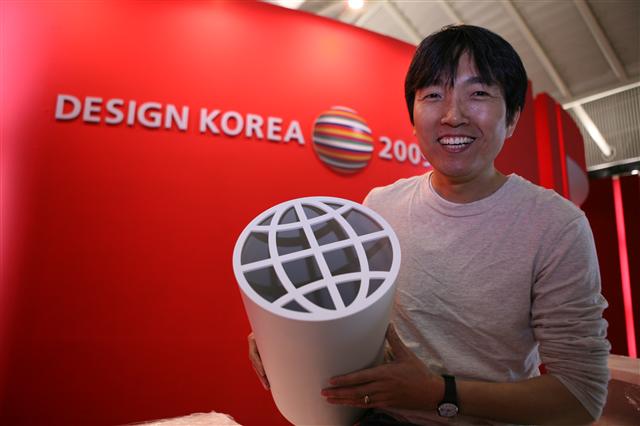 직접 디자인한 쓰레기통을 들어보이고 있는 성정기씨. ‘지구를 생각하라’는 이름을 붙였다. 미국에서 활동 중이다.  한국디자인진흥원