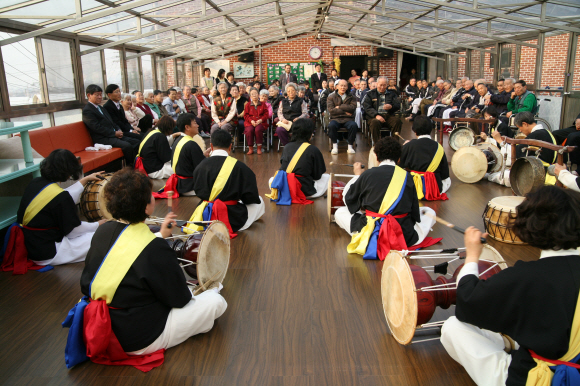 일산농협문화센터의 사물놀이팀 ‘한뫼’ 단원들이 일산의 한 양로원을 방문해 흥겨운 가락을 선물하고 있다. 이들은 10년간 100여차례나 공연을 다니며 힘들고 소외된 이웃들의 삶에 용기와 희망을 심어주고 있다.  일산농협문화센터 제공