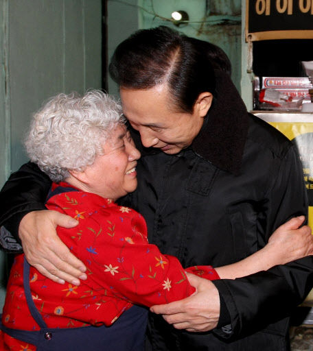 이명박 대통령이 12일 저녁 지난 대선 당시 선거광고에 나왔던 ‘욕쟁이 할머니’ 강종순씨의 실내 포장마차 식당을 깜짝 방문해 포옹하고 있다. 청와대 제공