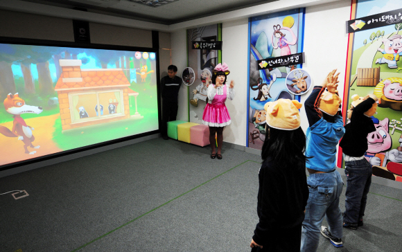 국립어린이도서관 가상현실 동화구연 체험관을 찾은 어린이들이 동화 ‘아기돼지 삼형제’ 중 늑대를 쫓아내는 장면을 시연하고 있다.