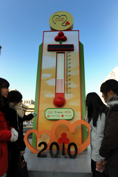 16일 서울 광화문광장을 찾은 시민들이 사회복지공동모금회가 설치한 ‘사랑의 행복 온도탑’을 바라보며 온정의 온도계를 보고 있다. 기부액의 규모를 나타내는 온도는 모금 시작 17일 만인 이날 현재 32.5도(719억원)를 가리키고 있다. 다음달 안에 모금 목표인 2212억원에 도달하면 100도가 된다. 이언탁기자 utl@seoul.co.kr