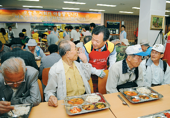 김중겸(왼쪽 두번째) 현대건설 사장이 지난 10월 노인 3000여명을 초청한 자리에서 식사대접을 하고 있다. 현대건설 제공