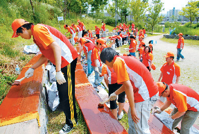 SK 건설 직원들과 그 가족들이 서울숲에서 쓰레기를 줍고 공원시설을 보수하고 있다. SK 건설 제공