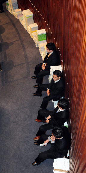 18일 민주당 의원들이 이틀째 점거 농성을 벌인 국회 예결위 회의장에서 일부 보좌관들이 예산안 관련 서류 더미에 앉아 있다. 이호정기자 hojeong@seoul.co.kr