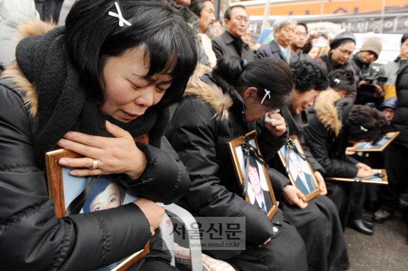 오열하는 유족  30일 서울 한강로2가 남일당 건물 앞에서 용산참사 타결 기자회견이 진행되자 유족들이 희생자들의 영정사진을 끌어안고 오열하고 있다. 도준석기자 pado@seoul.co.kr