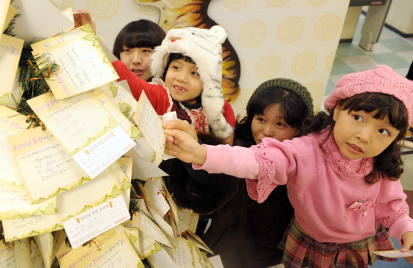 6일 서울 문래동 홈플러스 영등포점에서 열린 ‘희망 페스티벌’에서 어린이들이 ‘동생을 낳아주세요.’라는 신년 희망메시지를 적은 카드를 ‘희망나무’에 걸고 있다.  정연호기자 tpgod@seoul.co.kr