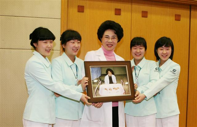 16일 네 자매가 이길여 길병원 이사장과 함께 21년 전 자신들이 태어날 당시의 사진을 들어보이고 있다. 길병원 제공