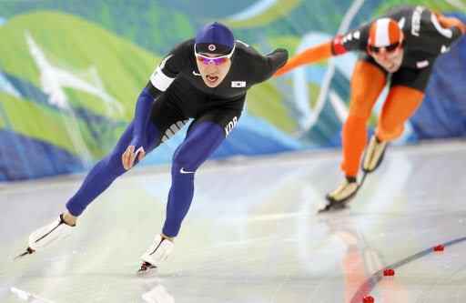 한바퀴 추월  이승훈(왼쪽)이 24일 리치먼드 올림픽 오벌 경기장에서 벌어진 스피드스케이팅 남자 1만m에서 올림픽 신기록을 세우면서 힘차게 코너를 돌고 있다. 밴쿠버 AP특약