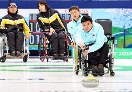 한국 휠체어컬링의 슈터 박길우(오른쪽)가 15일 캐나다 밴쿠버 패럴림픽센터에서 열린 일본과의 장애인동계올림픽 예선전에서 신중하게 스톤을 밀어 던지고 있다. 밴쿠버 연합뉴스