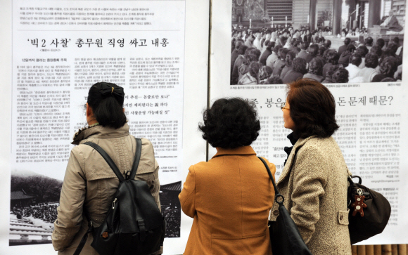 봉은사 신자들이 경내에 나붙은 직영사찰 전환 반대 결의문과 관련 기사들을 읽고 있다. 도준석기자 pado@seoul.co.kr