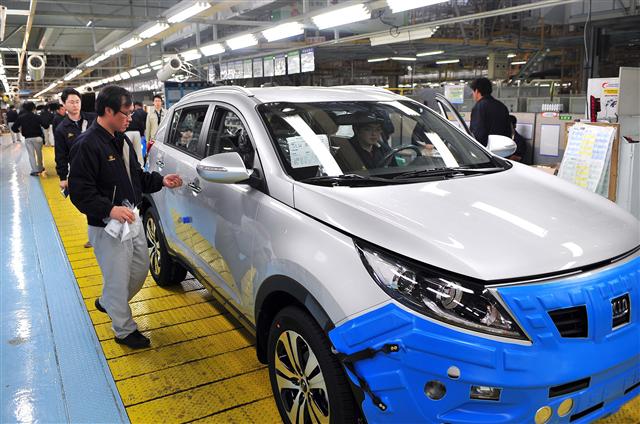지난달 30일 기아자동차 광주2공장에서 근로자들이 생산된 신차 ‘스포티지R’의 품질검사를 진행하고 있다.  기아차 제공 
