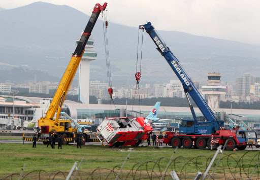 10일 오전 제주국제공항 남북방향 활주로에서 훈련중 전복된 한국공항공사 제주지역본부 소속 소방차를 대형 크레인 2대를 이용해 바로 세우고 있다. 연합뉴스