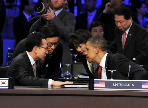 긴밀한 한·미 정상  이명박(왼쪽) 대통령과 버락 오바마 미국 대통령이 13일(현지시간) 미국 워싱턴 컨벤션센터에서 열린 제1차 핵안보정상회의 회의장에 나란히 앉아 통역들을 사이에 두고 긴밀히 대화를 나누고 있다. 연합뉴스