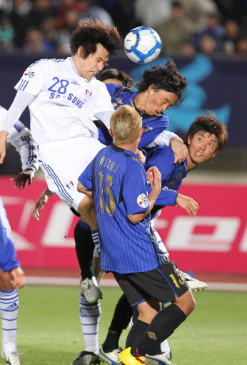 수원 양상민(왼쪽)이 13일 일본 오사카에서 열린 감바 오사카(일본)와의 아시아축구연맹(AFC) 챔피언스리그 조별리그 G조 5차전에서 상대 수비수 틈바구니를 헤집고 힘겹게 헤딩하고 있다. 오사카 사진공동취재단