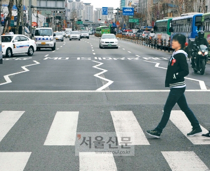 14일 오후 서울 영등포동 삼보예식장앞에서 시민들이 노면에 ‘지그재그 차선’이 그려진 횡단보도를 건너고 있다. 경찰은 사고가 잦은 횡단보도의 앞뒤 차선을 지그재그 형태로 그려 운전자의 경각심을 높이기로 했다. 김태웅기자 tuu@seoul.co.kr