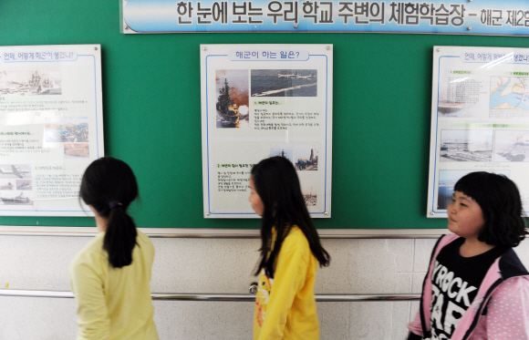 15일 경기 평택 해군 2함대 인근의 원정초등학교 학생들이 복도에 걸린 2함대 관련 홍보물을 유심히 살펴보고 있다.  도준석기자 pado@seoul.co.kr