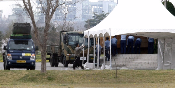 장례준비 시작  21일 ‘천안함’ 희생 장병들의 장례식이 해군장(5일장)으로 결정된 가운데 2함대 장병들이 장례식 때 사용될 시설물을 체육관 안으로 옮기는 등 준비를 하고 있다. 사진 공동취재단