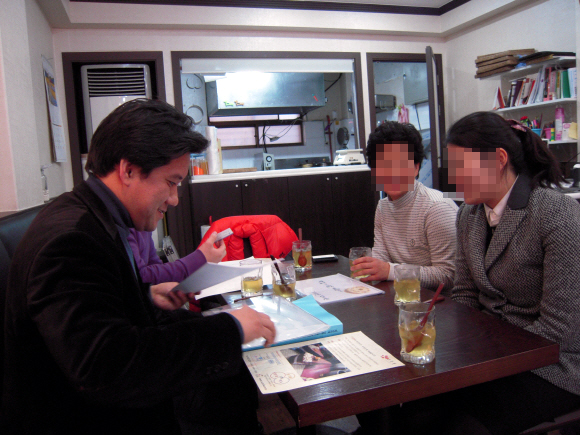 지난해 말 서울 대치동의 한 떡집에서 민간 마이크로크레디트 단체인 열매나눔재단 오승주 컨설턴트(왼쪽)가 대출 신청자들의 사업계획서를 보며 타당성을 검토하고 있다. 열매나눔재단 제공