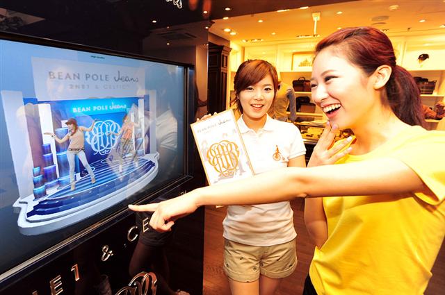 한 소비자가 2NE1이 제일모직 빈폴진을 소개하는 증강현실을 보며 즐거워하고 있다. 빈폴 제공