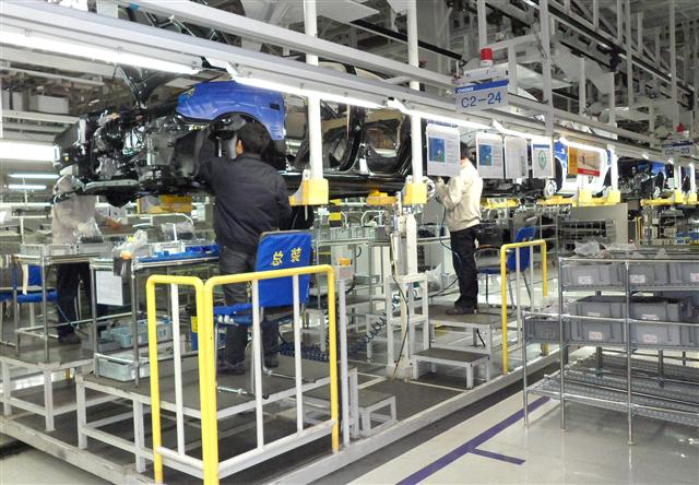 23일 베이징 현대자동차 2공장에서 근로자들이 차량 부품을 조립하고 있다.