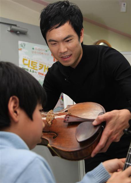 비올리스트 리처드 용재 오닐이 송파다문화가족센터에서 다문화가정 어린이에게 바이올린을 가르치고 있다.
