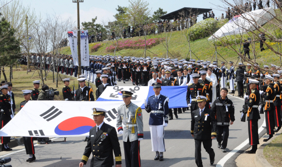 경기도 평택 해군 제2함대사령부 안보공원에서 천안함 46용사에 대한 합동영결식이 끝난 뒤 태극기를 앞세운 영현들이 운구되고 있다. 청와대사진기자단