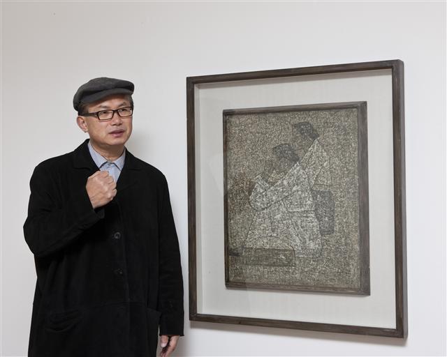 고 박수근의 차남으로 화가로 활동중인 박성남씨가 아버지의 작품 ´시장´ 앞에서 부친의 작품세계를 설명하고 있다.