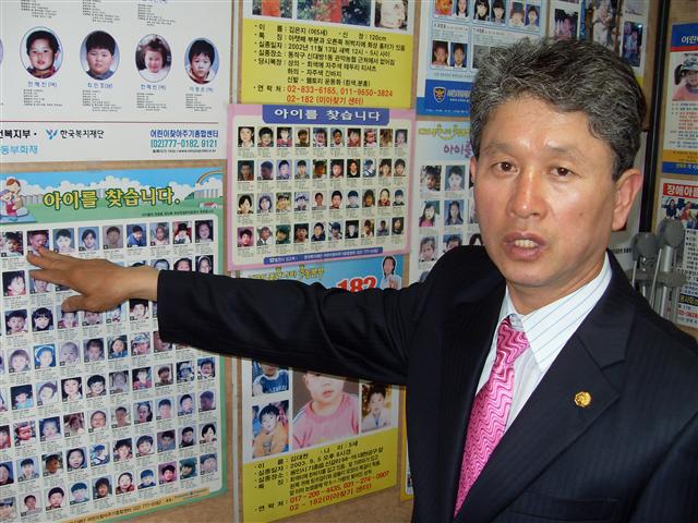 실종자 찾기에 20여년간 헌신해온 나주봉씨가 서울 청량리역 인근 사무실의 벽에 빼곡히 붙은 실종자 전단지를 가리키고 있다.