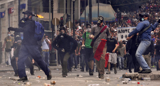 그리스 노동자들이 전국적인 총파업에 나선 5일(현지시간) 국회의사당 인근에서 최루탄에 대비해 방독면을 착용한 시위대가 화염병과 돌을 던지며 격렬한 시위를 벌이고 있다.  아테네 AP 특약