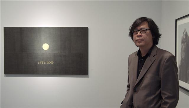 전업작가의 길을 걷겠다고 선언한 박찬경이 한국적 유토피아를 담아낸 자신의 회화 작품 ‘라이프 이즈 굿’ 앞에 서 있다.  PKM갤러리 제공