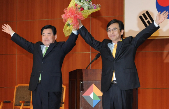 13일 오전 경기 수원 문화의전당에서 민주당과 국민참여당의 경기지사 단일 후보로 확정된 유시민(오른쪽) 후보가 경쟁자였던 민주당 김진표 후보와 함께 두 손을 들어 지지자들에게 인사하고 있다.  이호정기자 hojeong@seoul.co.kr