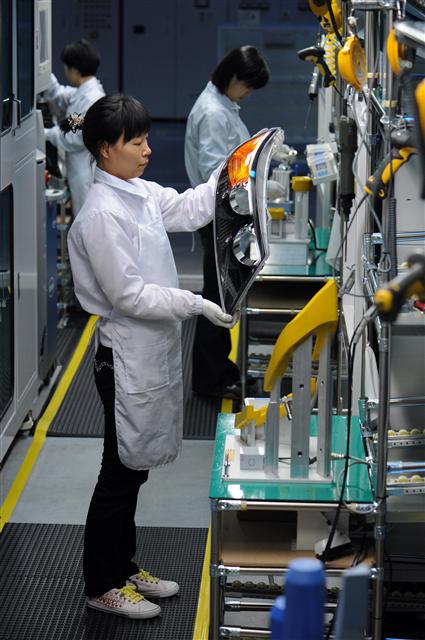 지난 14일 현대모비스 김천램프공장에서 여직원들이 기아차 쏘렌토R에 탑재될 헤드램프를 검사하고 있다. 현대모비스 제공
