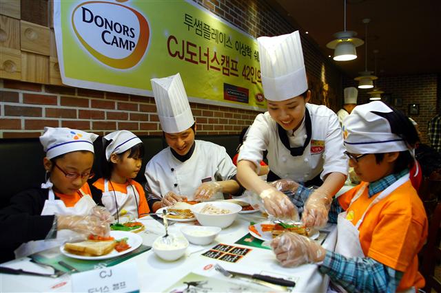 ‘CJ도너스캠프’에서 요리사들이 소외계층 어린이들에게 간식 만드는 법을 알려주고 있다. CJ그룹 제공