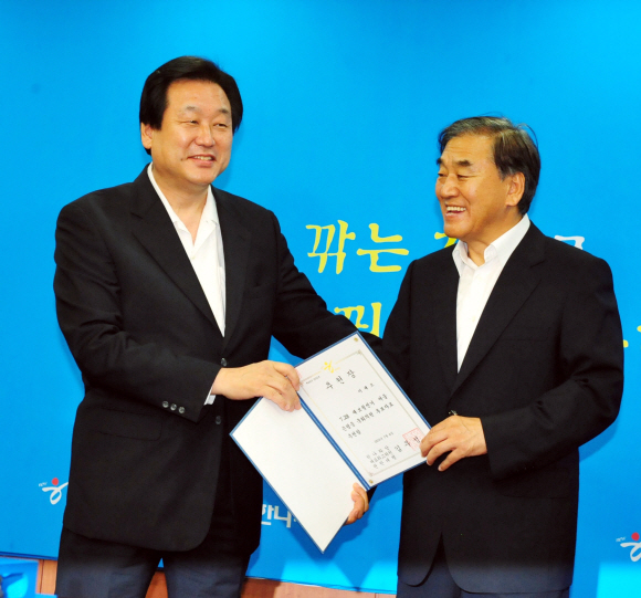 서울 은평을 재선거에 나선 이재오(오른쪽) 전 국민권익위원장이 지난 6일 오전 여의도 한나라당사에서 열린 7·28 재보궐선거 공직후보자 추천장 수여식에서 김무성 원내대표로부터 추천장을 받으며 활짝 웃고 있다. 이언탁기자 utl@seoul.co.kr
