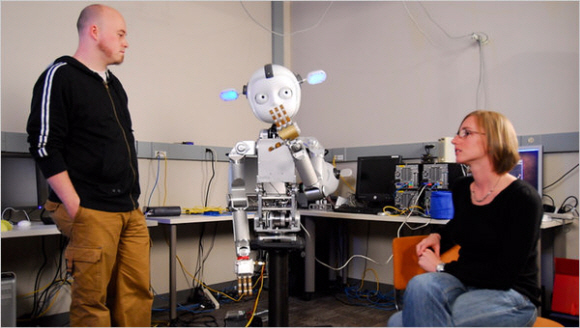미국 조지아공과대에서 상호작용 컴퓨터를 연구하고 있는 안드레아 토마즈(왼쪽)·닉 드팔마(오른쪽) 교수가 2009년 개발한 자폐아 교육용 로봇 ‘사이먼’을 살펴보고 있다. 뉴욕타임스 홈페이지
