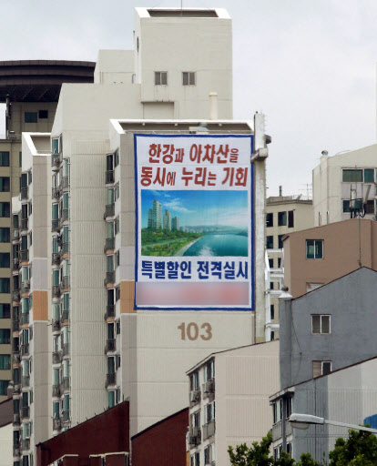 정부가 부동산 거래 활성화 방안을 22일 발표하기로 한 가운데 20일 서울의 한 아파트 벽면에 미분양 물량을 파격 할인판매한다는 현수막이 걸려있다.  연합뉴스