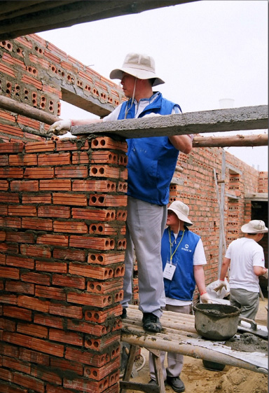 지난 4월 베트남 하노이 인근의 빈푹성으로 자원봉사 활동을 떠난 우리투자증권 직원이 기숙사 건물을 짓기 위해 벽돌을 쌓아올리고 있다. 우리투자증권 제공