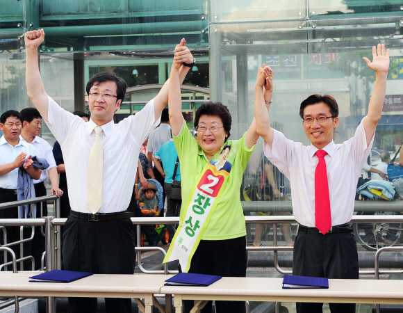 서울 은평을 야당 3당 단일 후보로 선출된 민주당 장상(가운데) 후보가 26일 국민참여당 천호선(왼쪽) 후보·민주노동당 이상규 후보와 손을 들어 인사하고 있다.  이호정기자 hojeong@seoul.co.kr