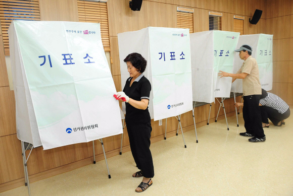 재보선 기표대 설치  7·28 재·보선을 하루 앞둔 27일 서울 은평구 불광보건소에서 선거관리위원회 관계자들이 기표대를 설치하고 있다.  이호정기자 hojeong@seoul.co.kr 