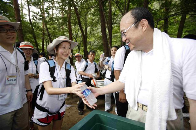 5일 경북 문경새재에서 김승연(오른쪽) 한화 회장이 ‘사랑의 행진’ 행사 도중 인턴사원들에게 음료수를 나눠 주고 있다.  한화 제공