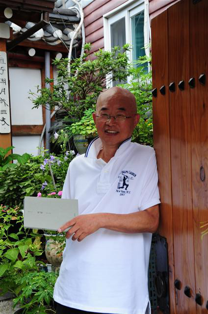 송기원 시인이 18일 서울 인사동에서 자신의 네 번째 시집 ‘저녁’을 읽으며 활짝 웃고 있다.