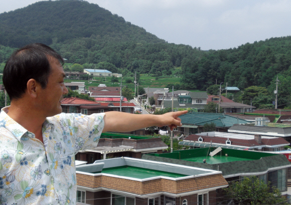 박해담(50) 녹색 에너지 자립마을 추진위원장이 22일 에너지 자립 마을 시설물이 들어설 후보지 인근에 위치한 공주시 계룡면 월암리의 주거지를 소개하고 있다.