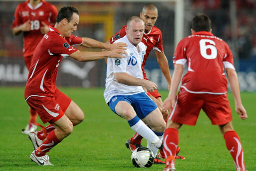 잉글랜드 축구대표팀의 웨인 루니(가운데)가 8일 유럽축구선수권대회(유로2012) 예선 2차전에서 강한 압박을 펼치는 스위스 선수들에 둘러싸인 채 힘겹게 공을 다루고 있다.  바젤 AP 특약